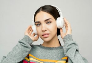 Portrait d'une jeune femme portant un casque audio, profitant de la musique à l'intérieur avec une expression décontractée
