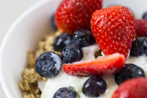Close-up of fresh blueberries and strawberries on yogurt with granola. Gros plan de myrtilles fraîches et fraises sur du yaourt avec du granola.
