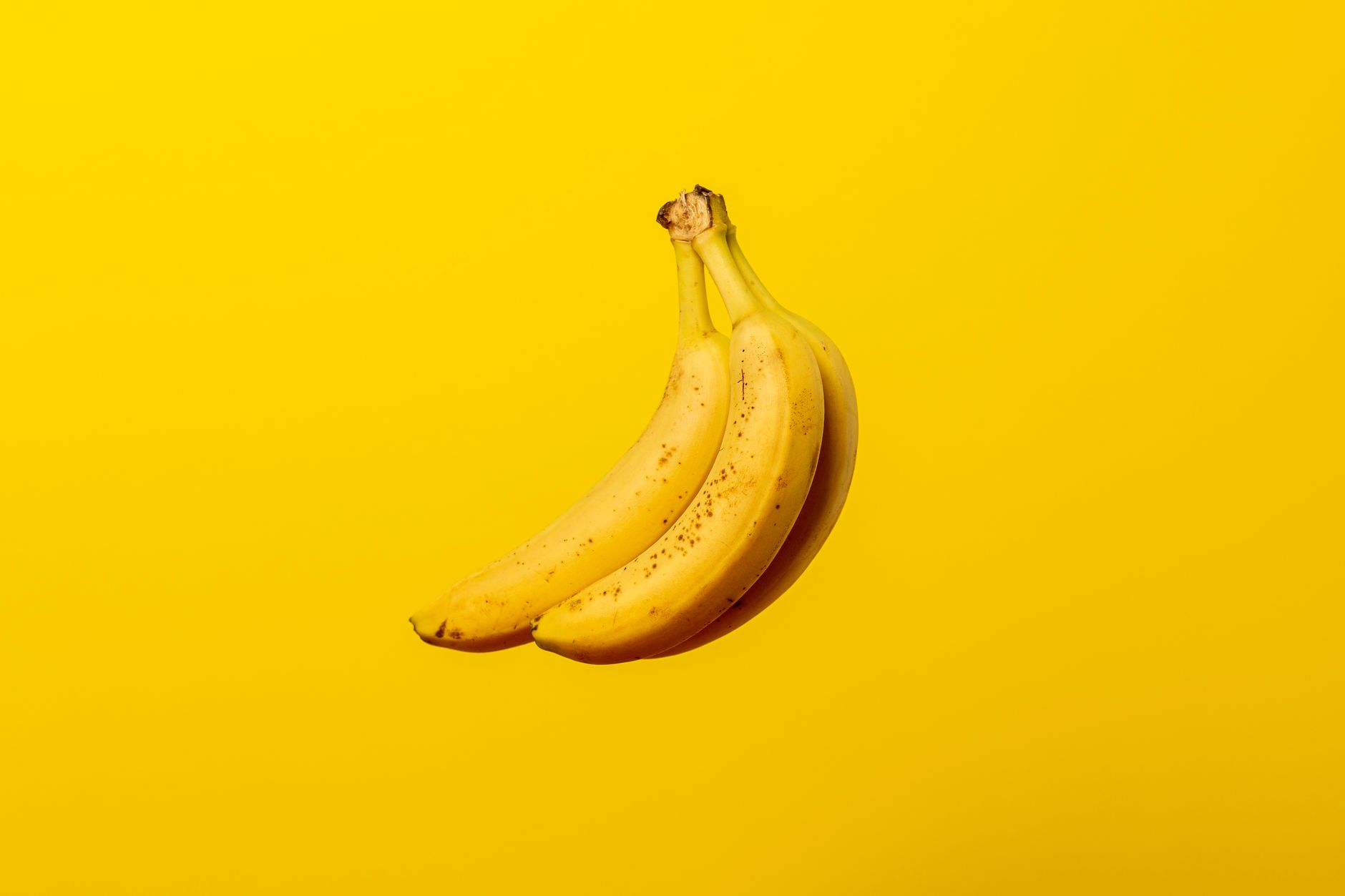 Bouquet de bananes mûres sur fond jaune vif