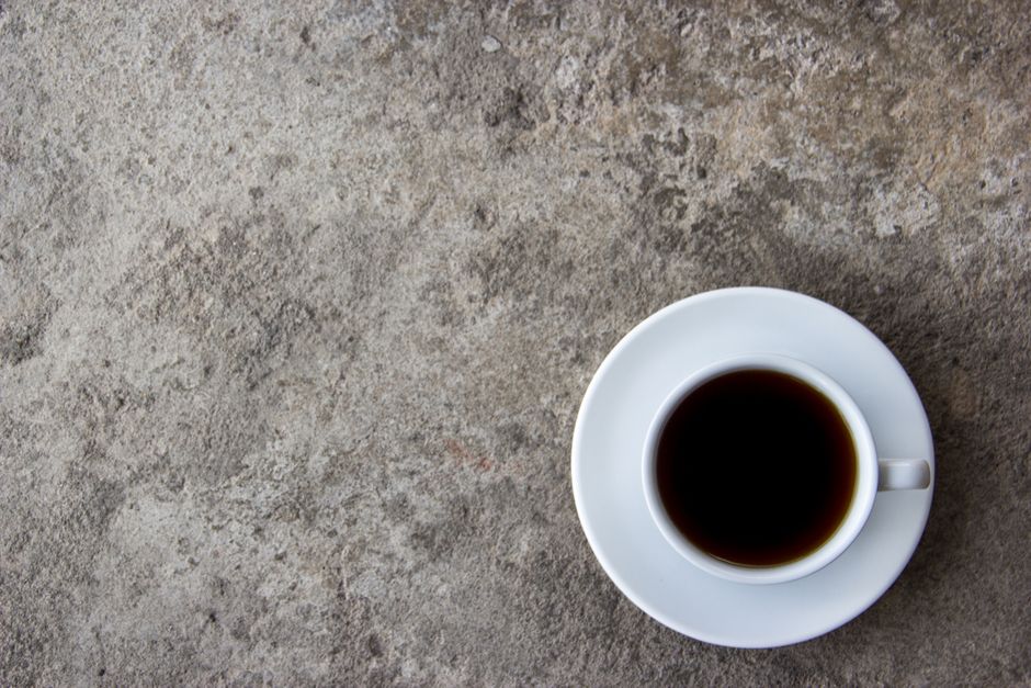 Café filtre versé lentement dans une tasse blanche