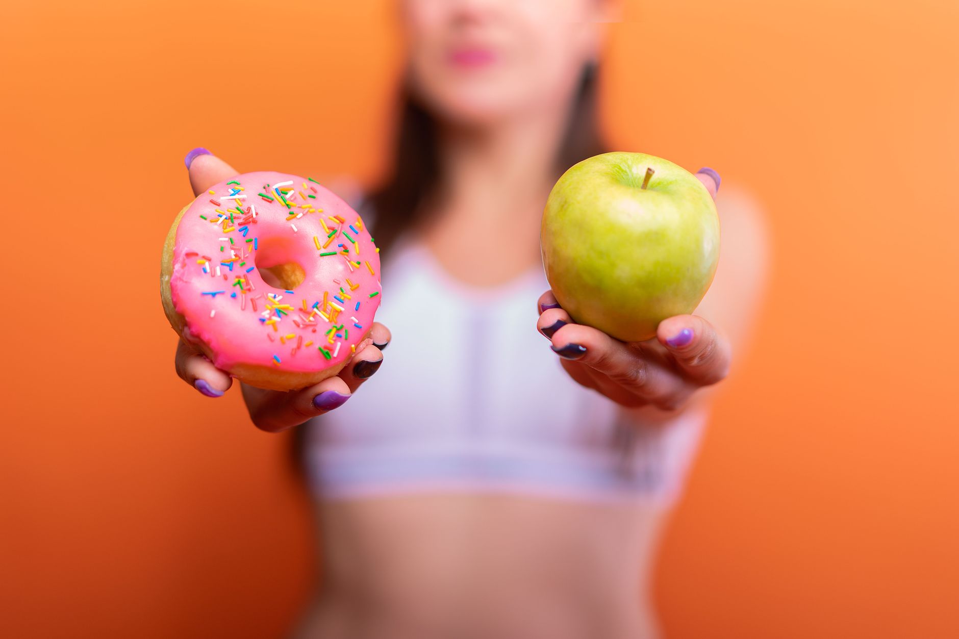 Pomme verte et donut représentant un choix alimentaire