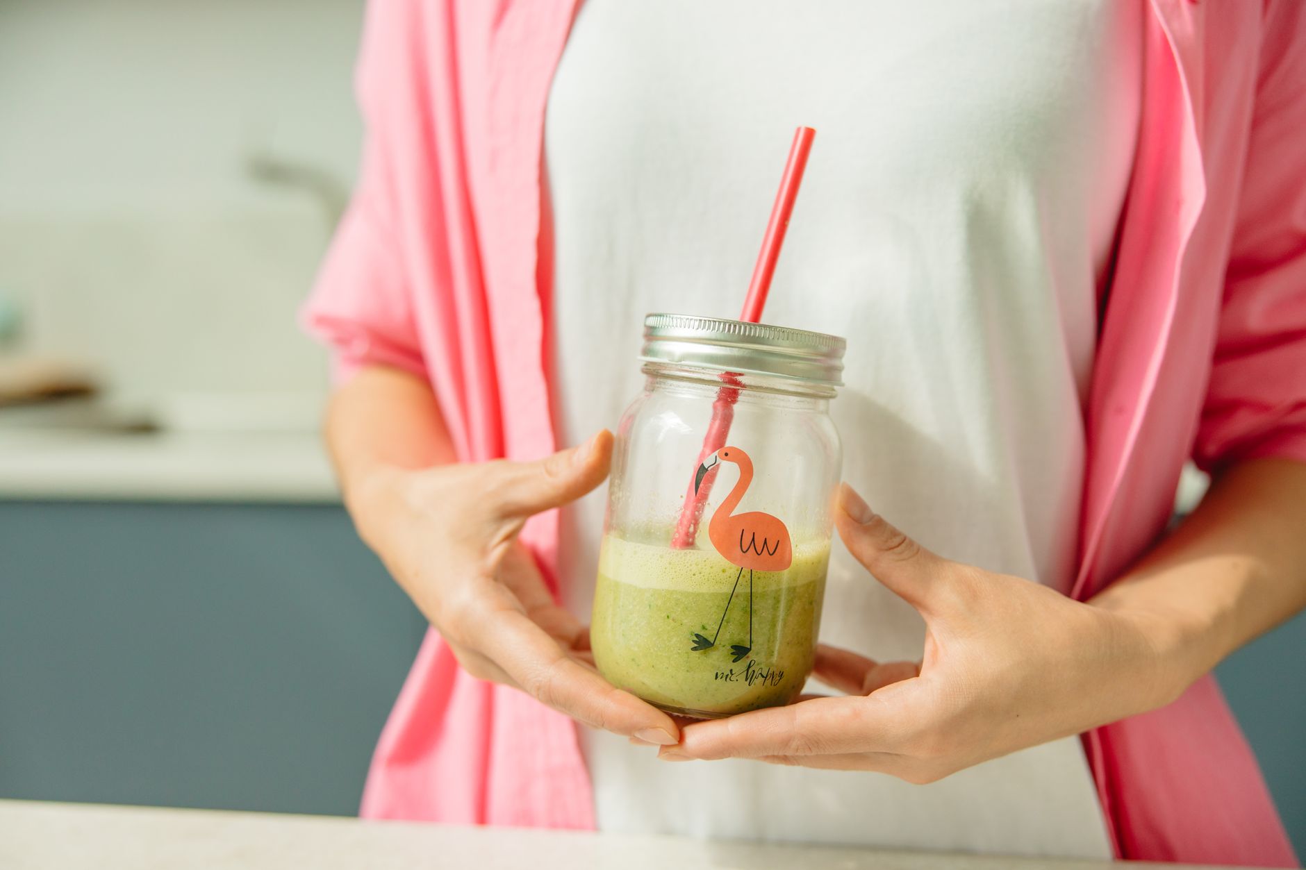 Femme sportive tenant un smoothie vert