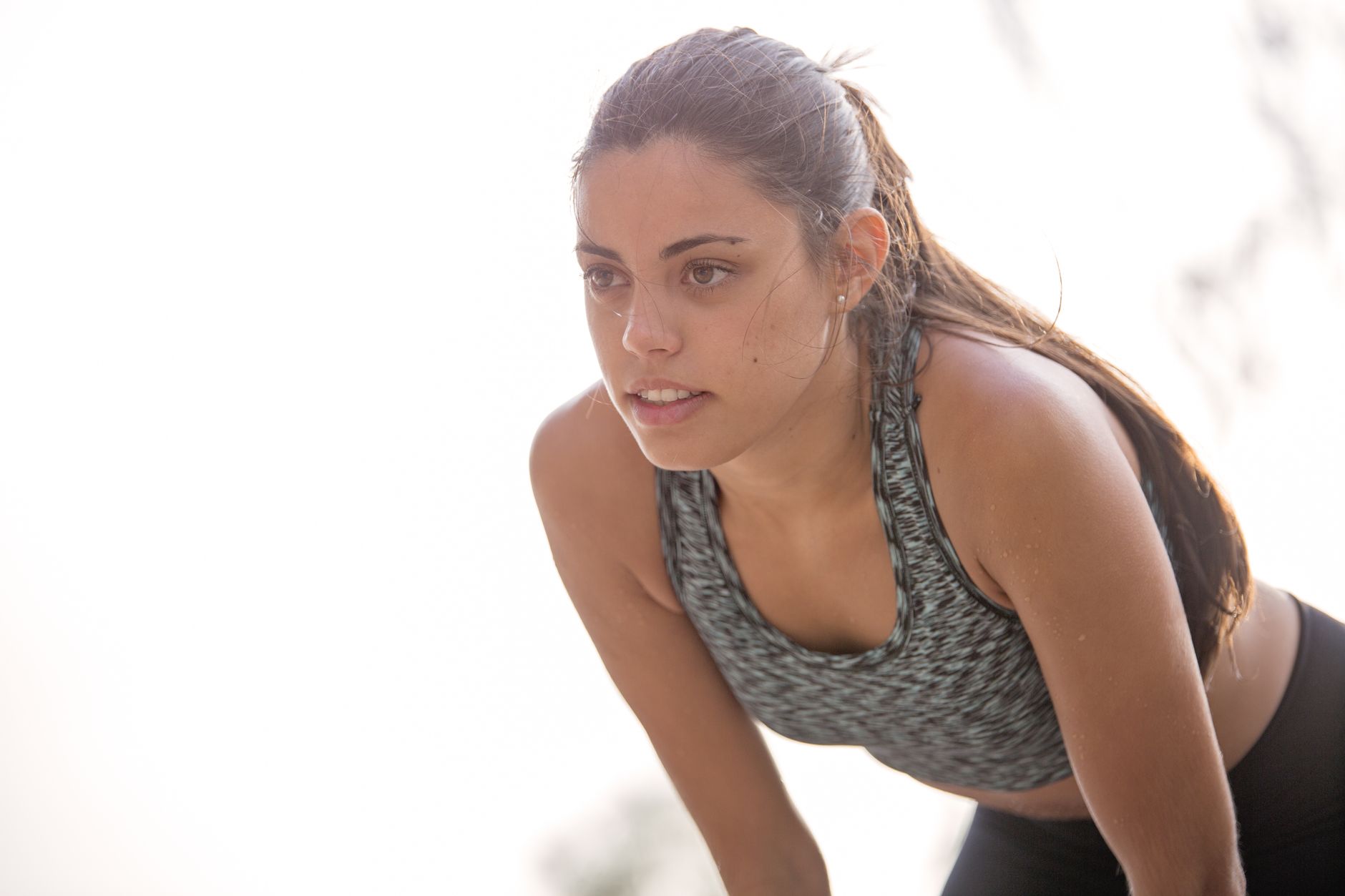 Sportive concentrée en posture de récupération en extérieur