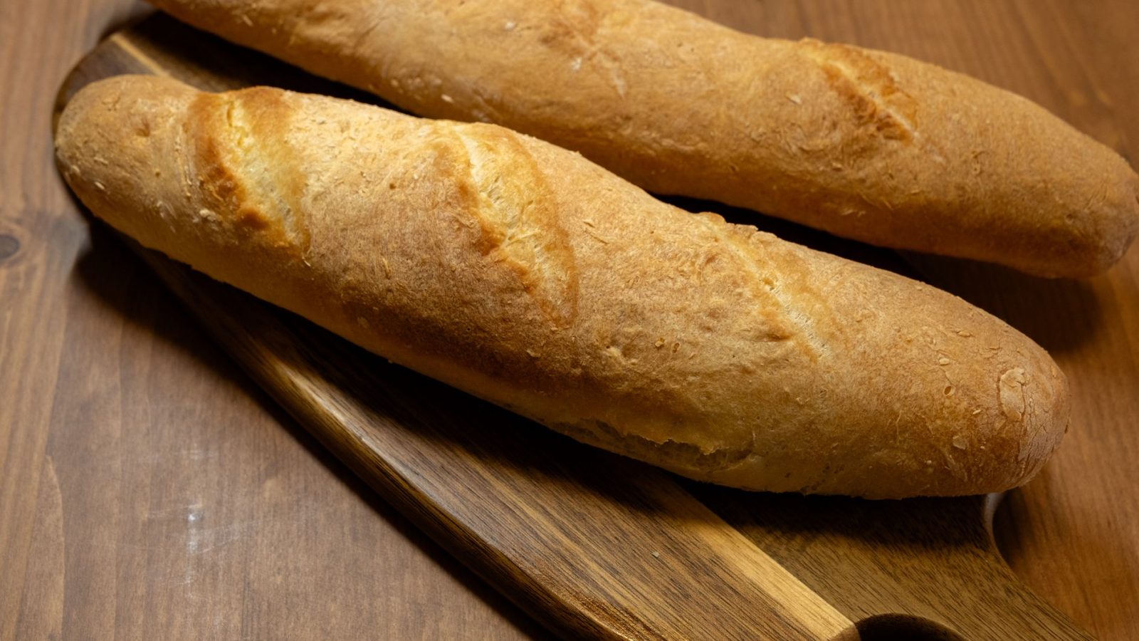Deux baguettes croustillantes sur une planche en bois