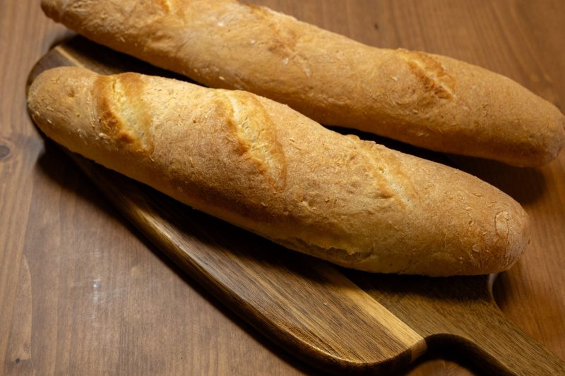Deux baguettes croustillantes sur une planche en bois