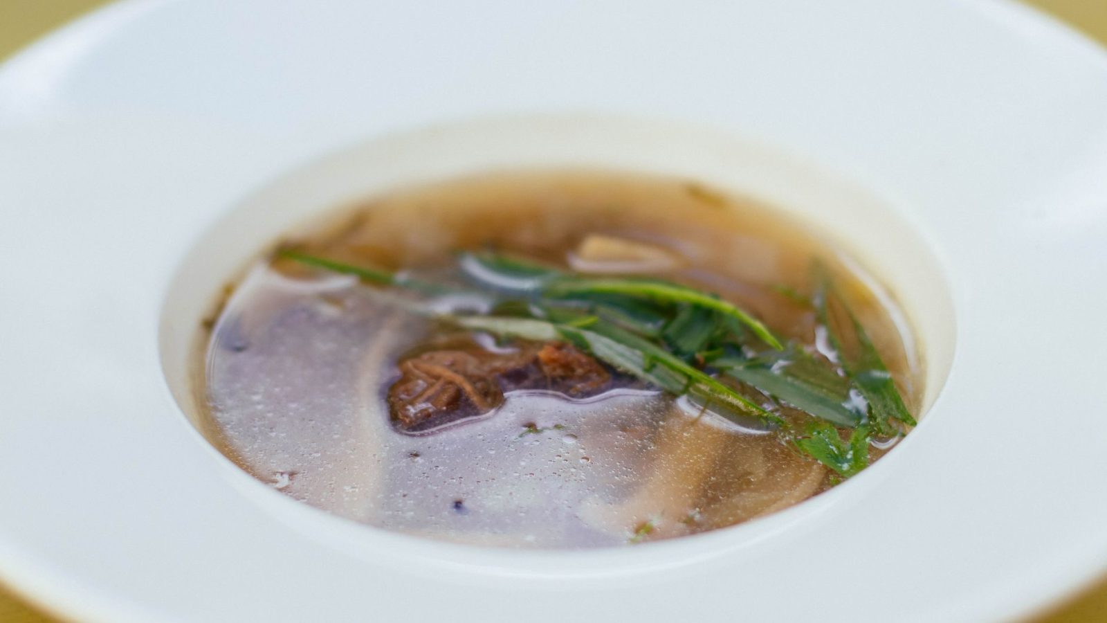 Bol de bouillon clair à la viande et aux herbes
