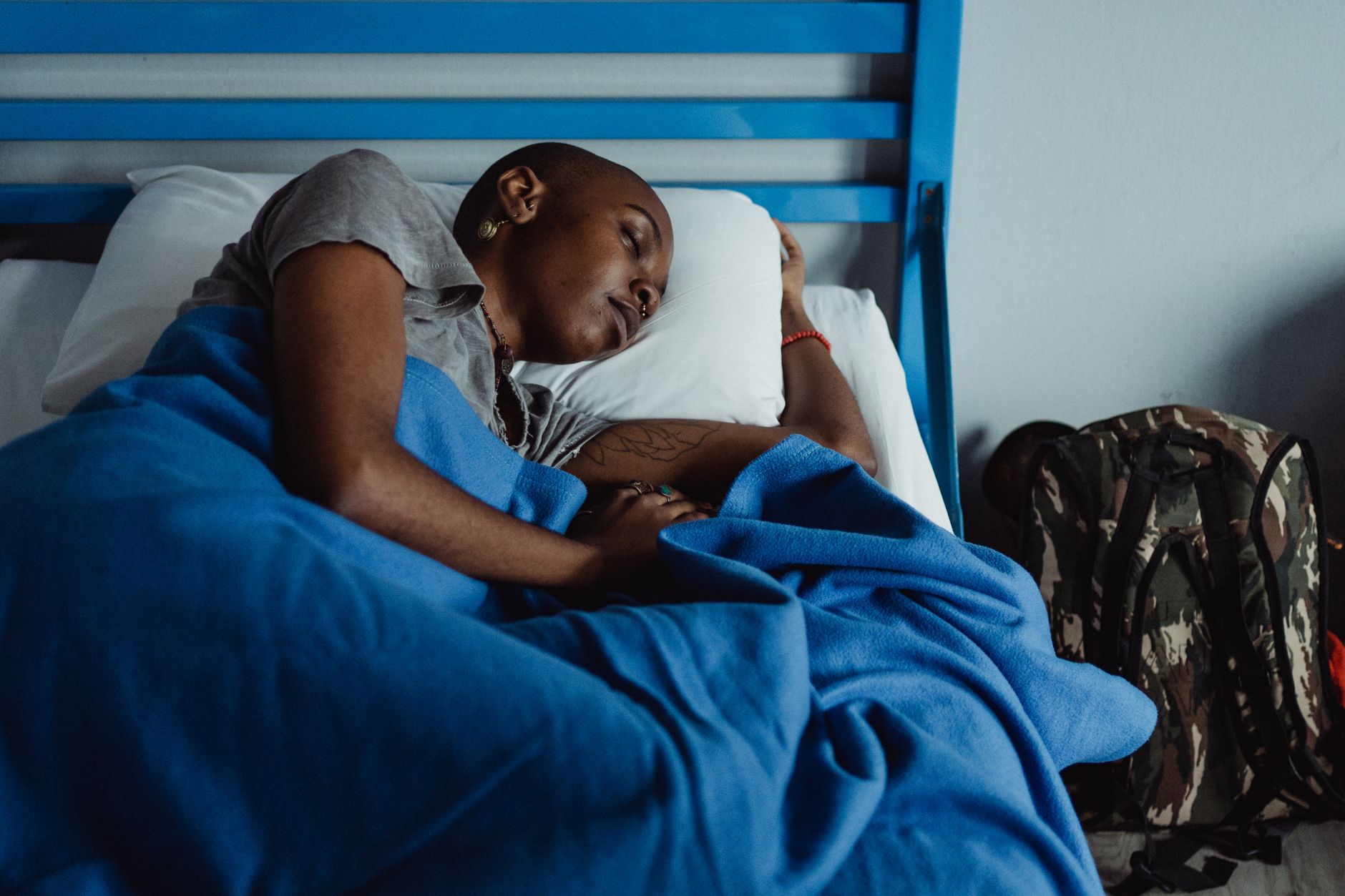Femme allongée au calme sous une couverture bleue