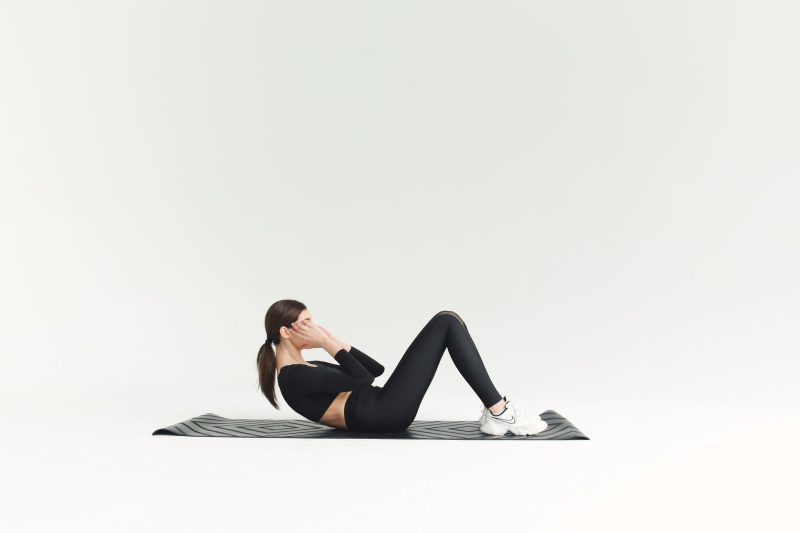 Femme faisant des relevés de buste sur un tapis de yoga