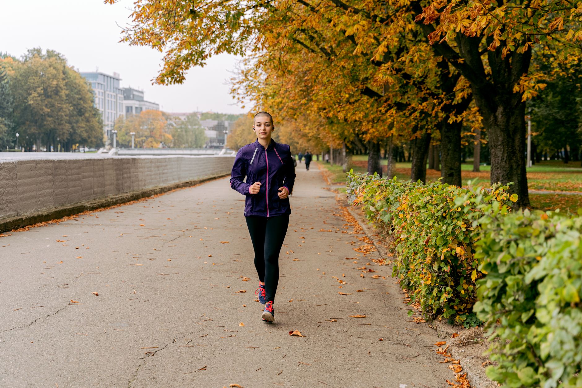 Joggeuse sur un chemin du parc en automne